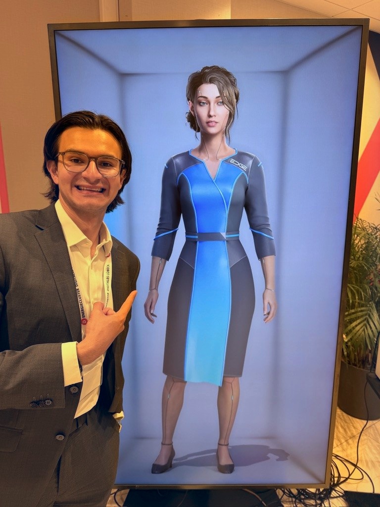 Eddie neben einem KI-Avatar auf einem großen Bildschirm