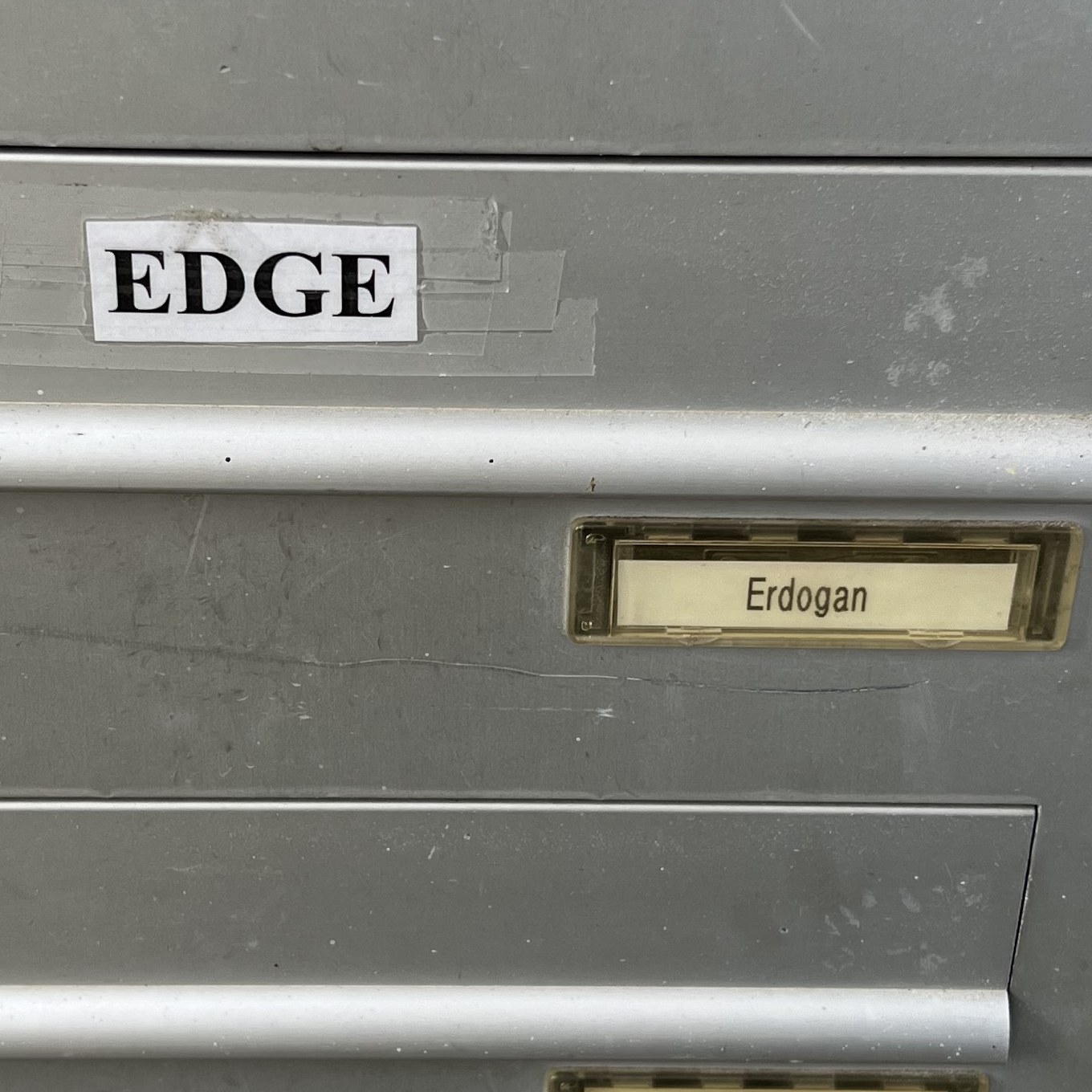 Zettel EDGE am Briefkasten über dem Schild Erdogan