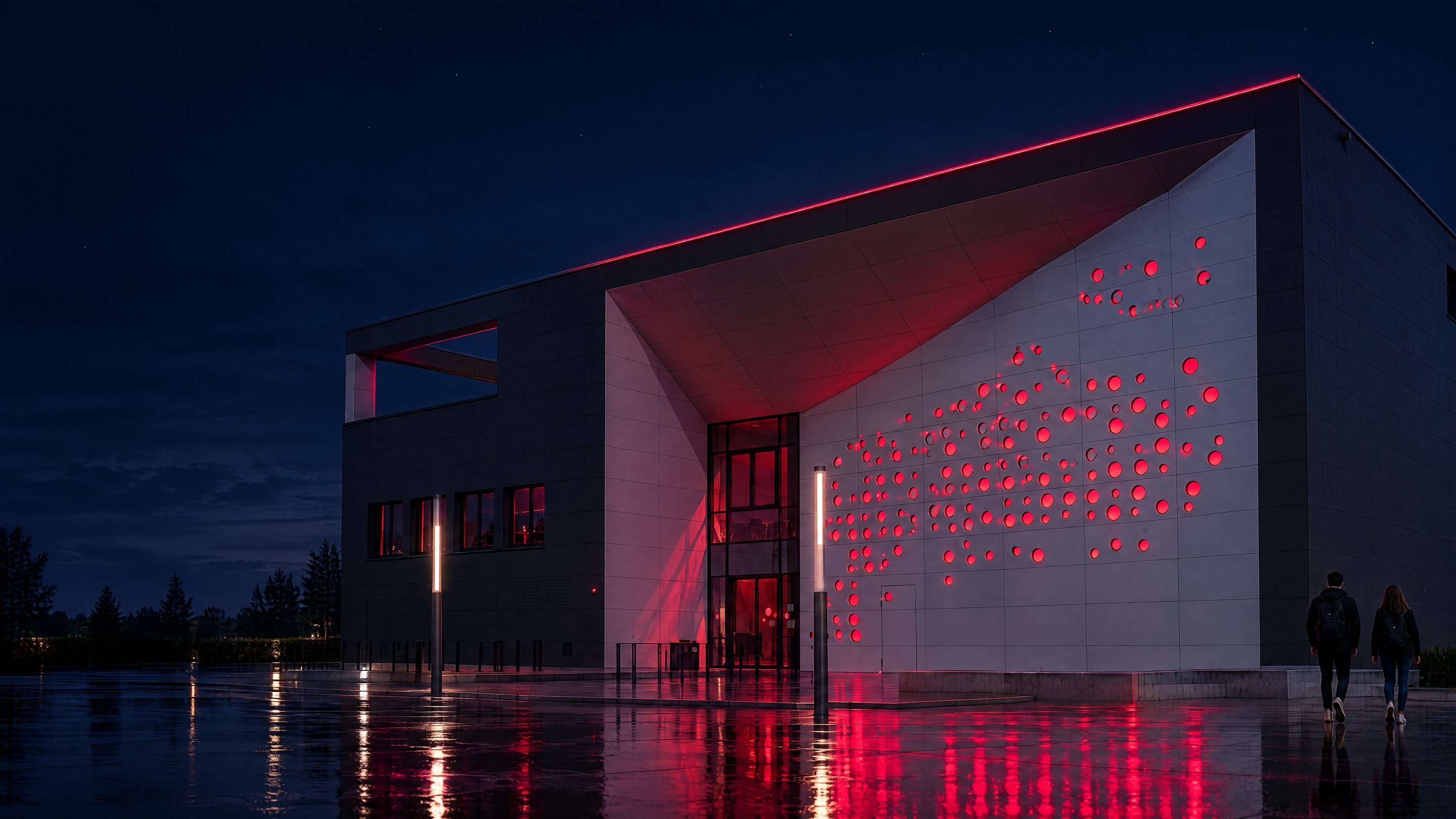 Das Seminargebäude der TH Lübeck bei Nacht, die Punktfassade leuchtet rot